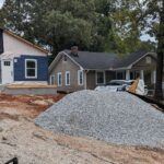 A manufactured home with a pile of gravel infront of it