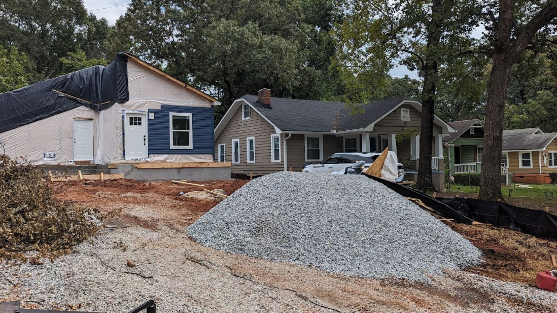 A manufactured home with a pile of gravel infront of it